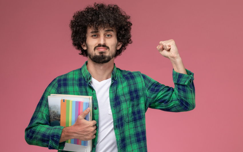 Front view young man showing his strength with notebooks