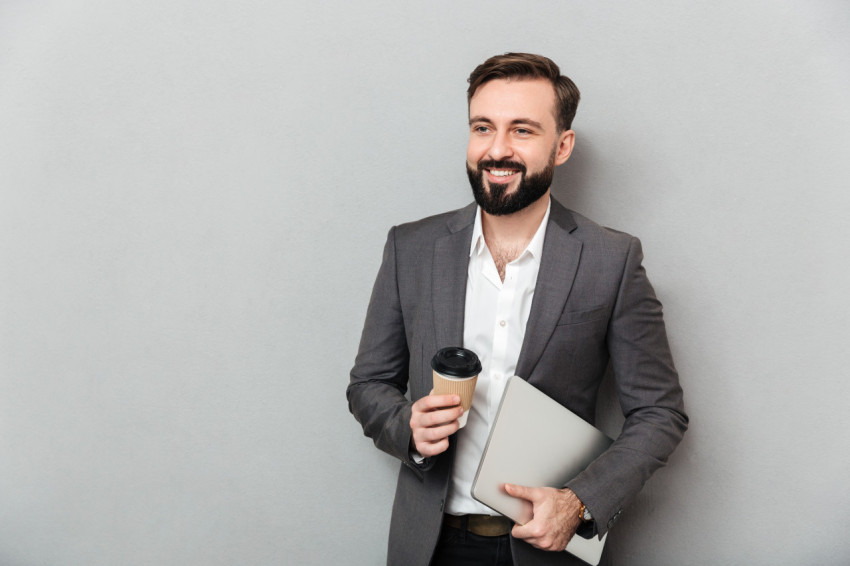 Portrait of cheerful male office worker posing on camera holding